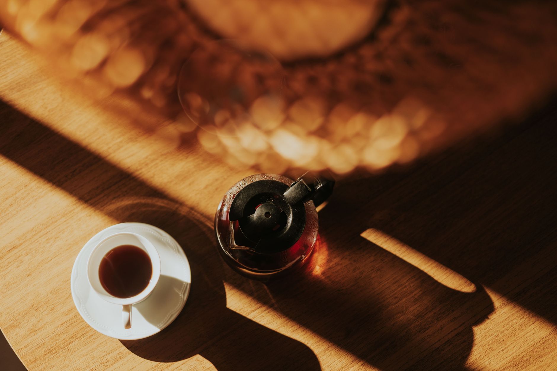 Kitchen table in a Montana ranch house with morning light, coffee cups, papers, no people